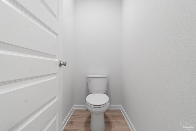 bathroom featuring wood-type flooring and toilet