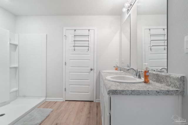 bathroom featuring a shower, hardwood / wood-style floors, vanity, and a textured ceiling