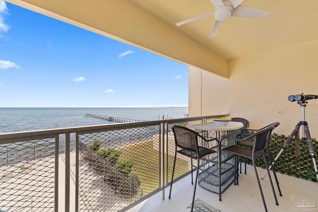 balcony with a water view, a beach view, and ceiling fan