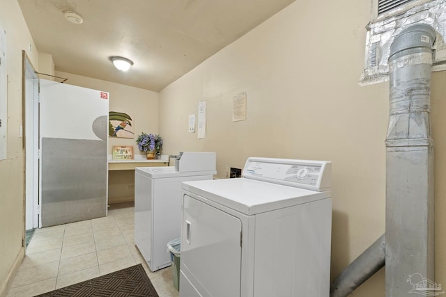 clothes washing area featuring light tile patterned floors and separate washer and dryer