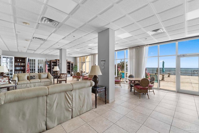 tiled living room featuring expansive windows and a water view