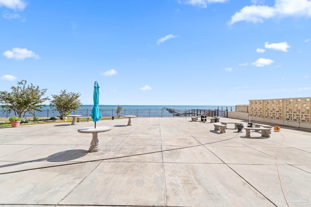 surrounding community featuring an outdoor fire pit, a patio area, and a water view