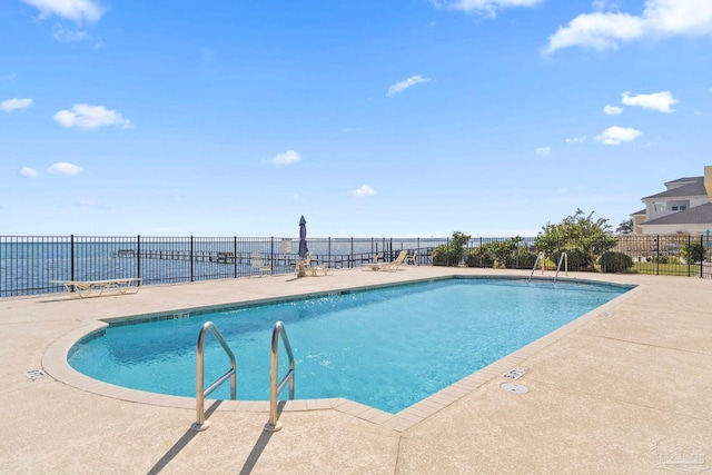 view of pool featuring a water view and a patio