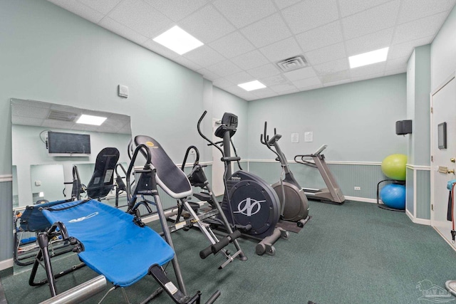 workout area with a drop ceiling and dark colored carpet