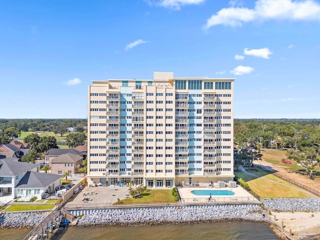 view of property with a community pool and a water view