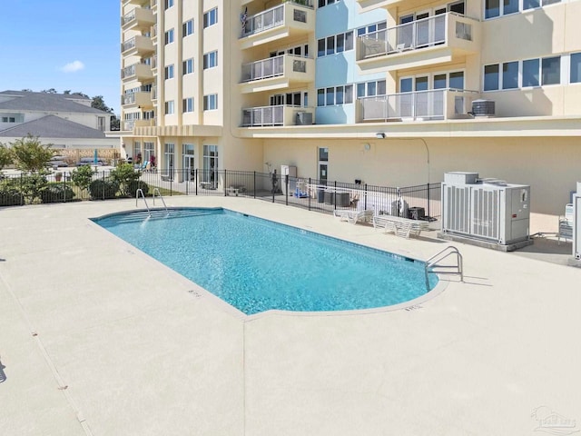 view of pool featuring a patio and central AC unit