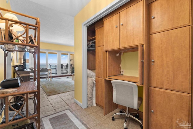 office with a textured ceiling and light tile patterned floors