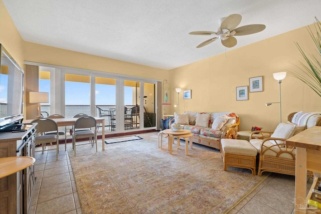 tiled living room featuring ceiling fan and a textured ceiling