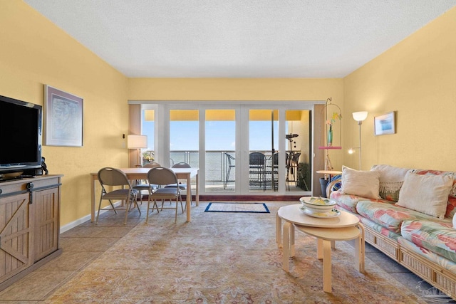 living room with a water view and a textured ceiling