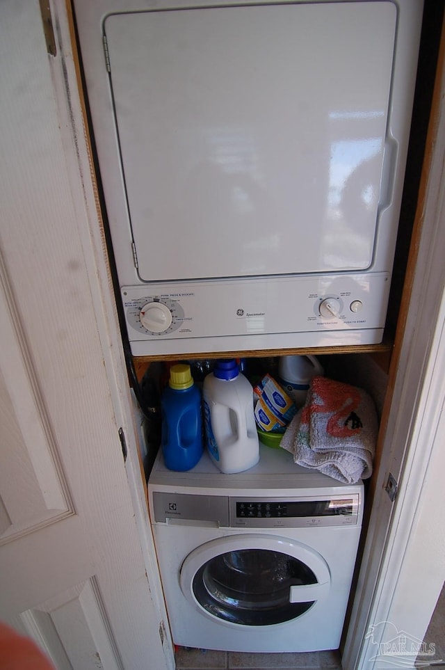 clothes washing area featuring stacked washer / dryer