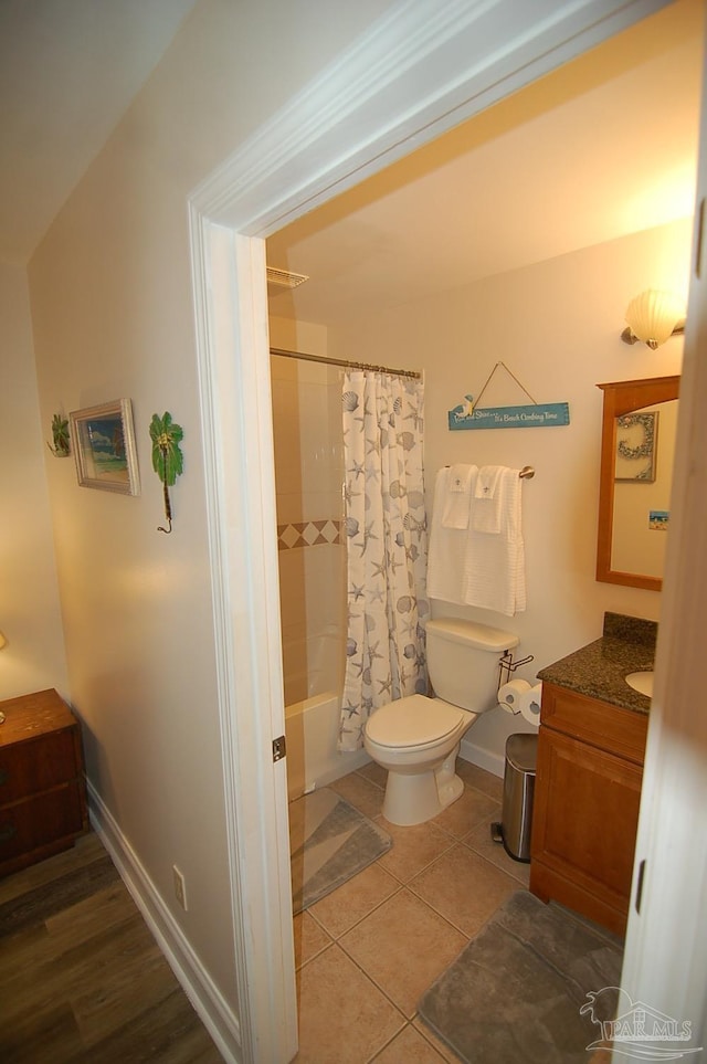 full bathroom featuring tile patterned flooring, vanity, shower / tub combo with curtain, and toilet