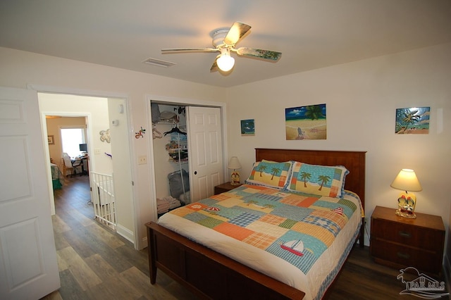 bedroom with dark wood-type flooring, ceiling fan, and a closet