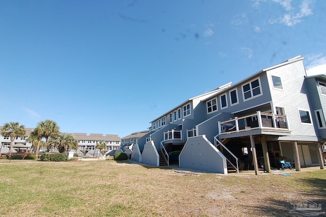 rear view of property featuring a lawn and a wooden deck