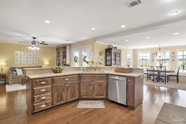 kitchen with a sink, visible vents, light countertops, and dishwasher