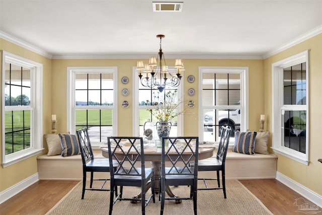 dining space with baseboards, visible vents, a notable chandelier, and wood finished floors