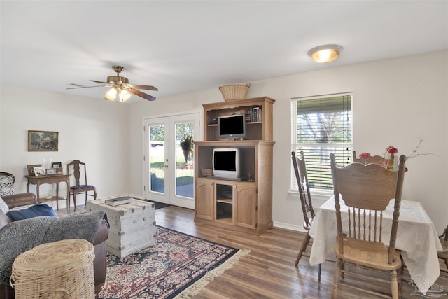 living area with baseboards, wood finished floors, french doors, and a ceiling fan