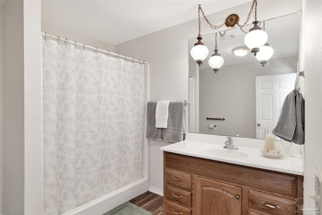 full bathroom featuring a shower with curtain, visible vents, wood finished floors, and vanity