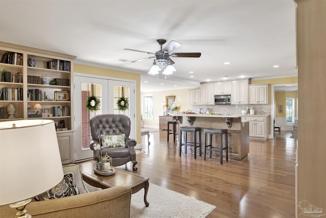 living room featuring ornamental molding, recessed lighting, a ceiling fan, and light wood finished floors