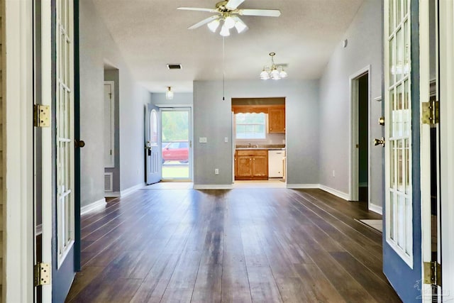 interior space with dark wood-style floors, visible vents, ceiling fan with notable chandelier, and baseboards