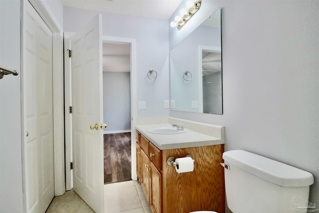 bathroom featuring tile patterned flooring, toilet, and vanity