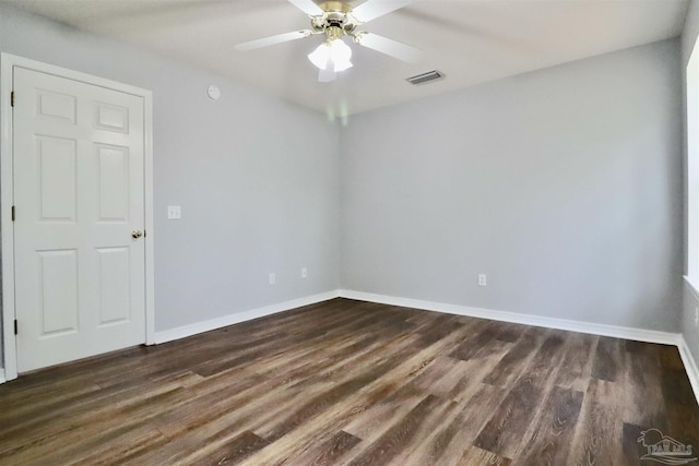 empty room featuring visible vents, baseboards, dark wood finished floors, and a ceiling fan