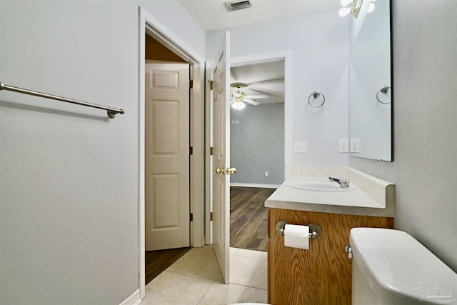 bathroom with vanity, baseboards, visible vents, tile patterned flooring, and toilet