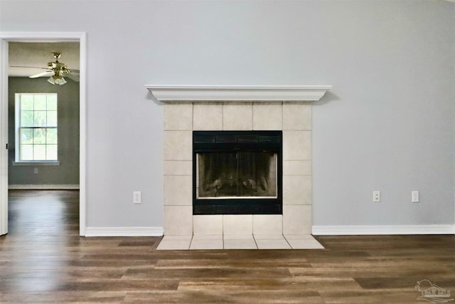 details with a tiled fireplace, wood finished floors, baseboards, and a ceiling fan