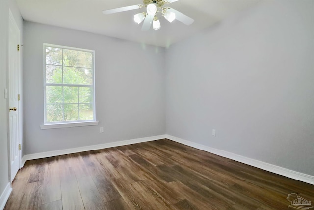 spare room featuring a ceiling fan, baseboards, and dark wood-style flooring