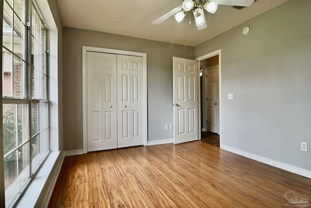 unfurnished bedroom with a closet, baseboards, and light wood-style flooring