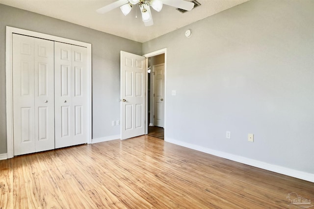 unfurnished bedroom with a closet, a ceiling fan, baseboards, and light wood finished floors