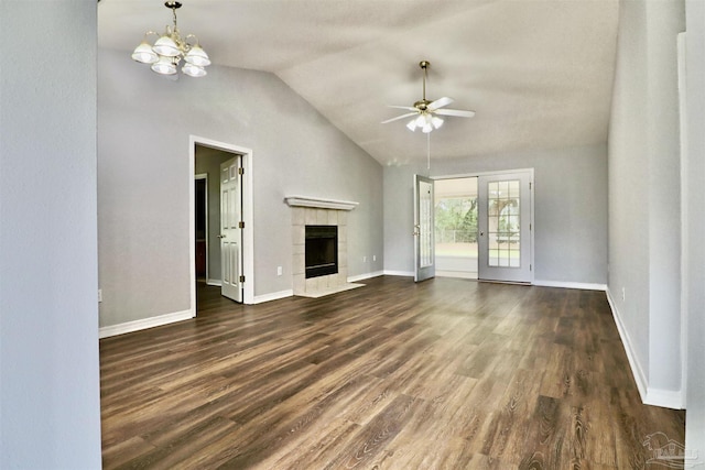 unfurnished living room with ceiling fan with notable chandelier, a fireplace, dark wood-type flooring, and baseboards