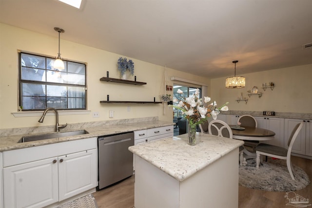 kitchen with white cabinetry, a kitchen island, open shelves, a sink, and dishwasher