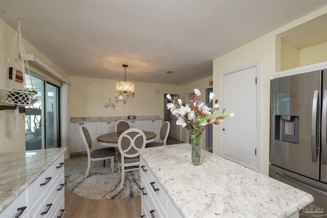 dining area with visible vents and wood finished floors