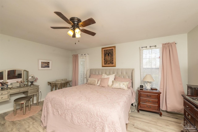 bedroom featuring light wood finished floors, baseboards, and a ceiling fan