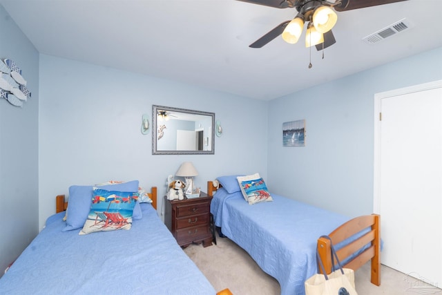 bedroom with visible vents, light colored carpet, and ceiling fan