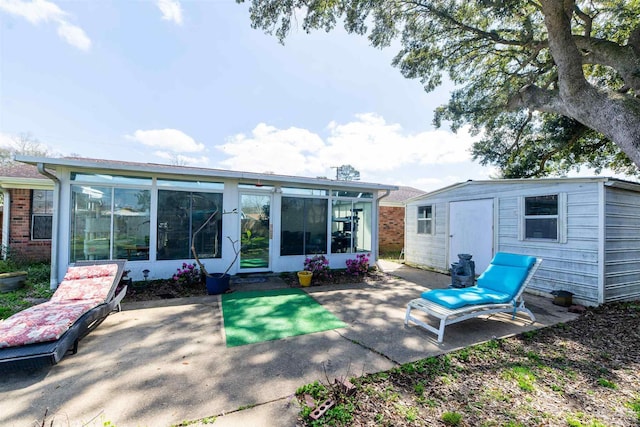 back of house featuring a patio area, an outdoor structure, and a sunroom