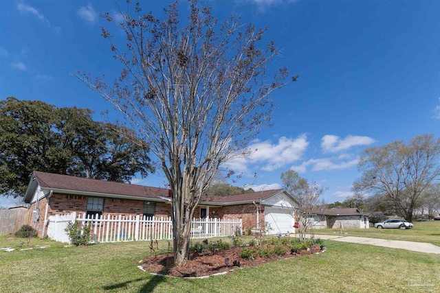 ranch-style house with a front yard, concrete driveway, a garage, a fenced front yard, and brick siding