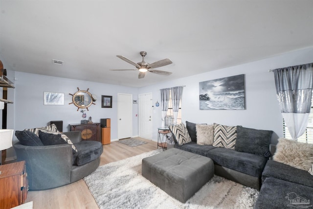 living area featuring light wood-type flooring, visible vents, and ceiling fan
