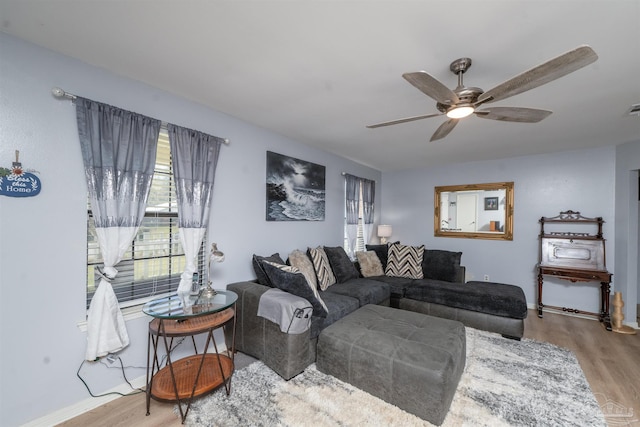 living area featuring ceiling fan, visible vents, baseboards, and wood finished floors