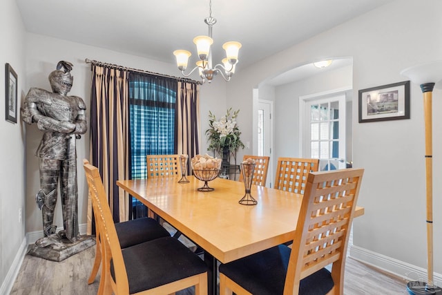 dining space featuring an inviting chandelier and light hardwood / wood-style floors