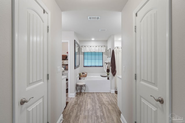 bathroom featuring independent shower and bath and hardwood / wood-style floors