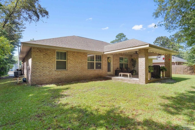 rear view of property with a lawn, a patio, and central AC unit