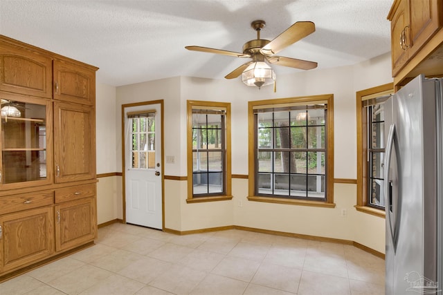 2821 Mandeville Ln, Pensacola, FL 32526 - kitchen with freestanding refrigerator, plenty of natural light, brown cabinets, and a textured ceiling