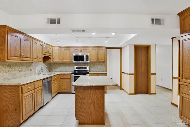 2821 Mandeville Ln, Pensacola, FL 32526 - kitchen with appliances with stainless steel finishes, a sink, tasteful backsplash, light stone counters, and a kitchen island