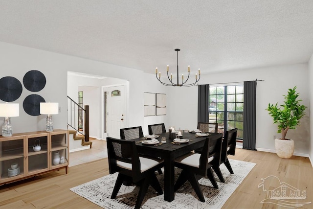 2821 Mandeville Ln, Pensacola, FL 32526 - dining room with a chandelier, stairway, light wood-style flooring, and baseboards