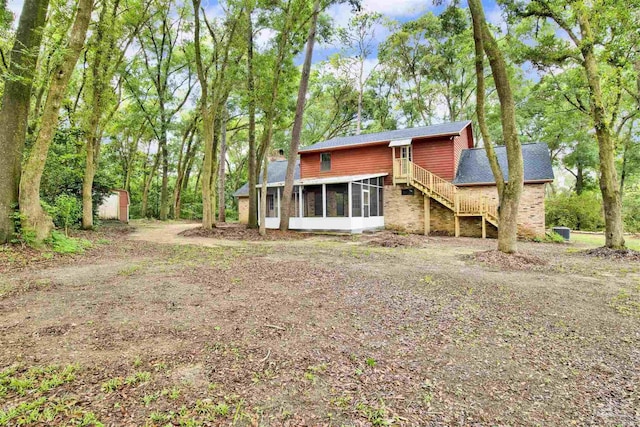 2821 Mandeville Ln, Pensacola, FL 32526 - rear view of house featuring a sunroom, brick siding, and a shingled roof
