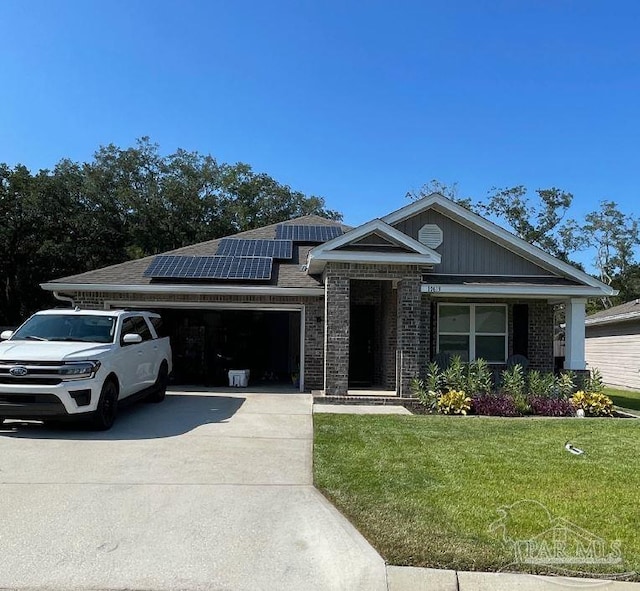 view of front of home with a garage, solar panels, and a front yard