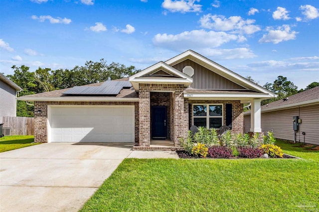 craftsman house featuring a garage, a front yard, and solar panels