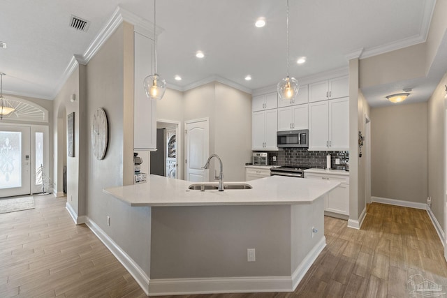 kitchen with light hardwood / wood-style flooring, white cabinets, sink, and stainless steel appliances