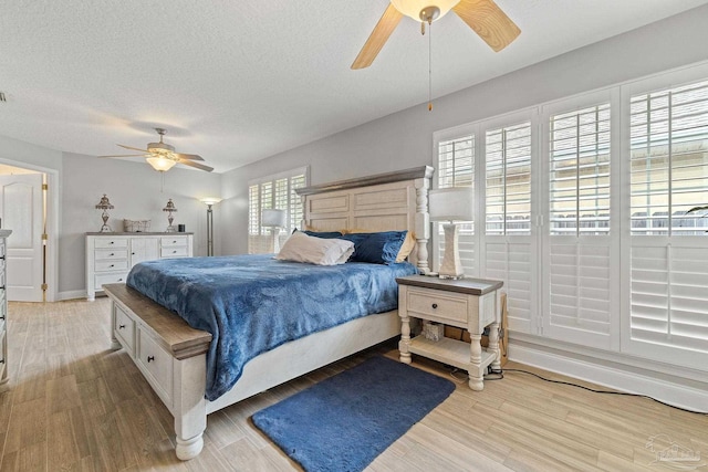 bedroom with multiple windows, light hardwood / wood-style floors, and ceiling fan